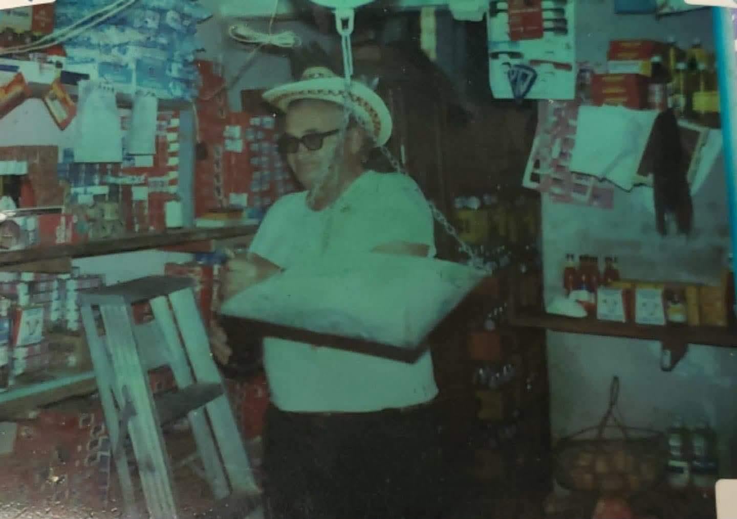 Our abuelo in his Venezuelan cornershop, surrounded by shelves and hanging goods
